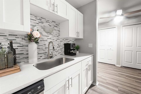 a kitchen with white cabinets and a sink