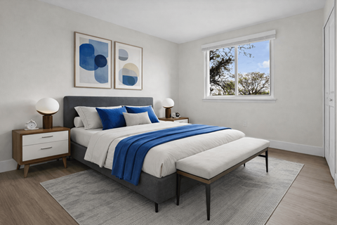 A bedroom with a large bed and two nightstands.