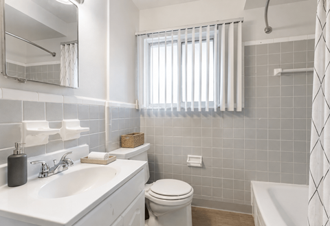 A white bathroom with a toilet, sink, and bathtub.