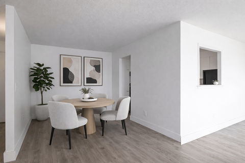 A dining room with a table and chairs.