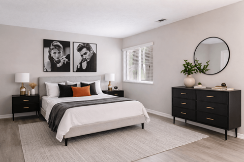 A bedroom with a large bed, a nightstand, and a dresser.