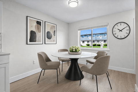 A dining room with a table and chairs.