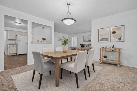 A dining room with a table and chairs.