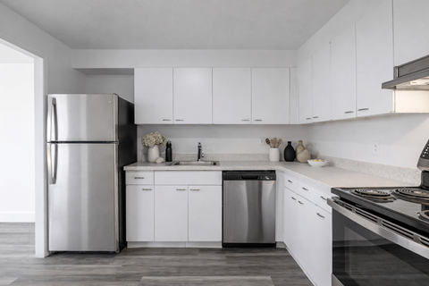 A modern kitchen with white cabinets and stainless steel appliances.