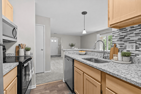 A kitchen with a black oven and a white counter.