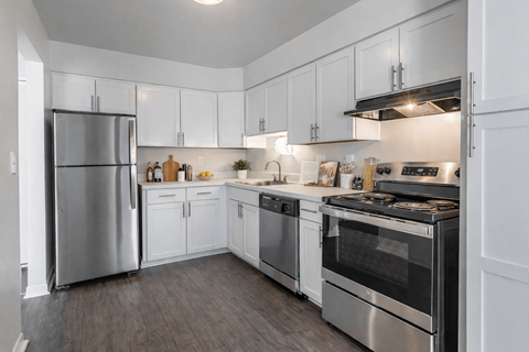 A modern kitchen with white cabinets and stainless steel appliances.