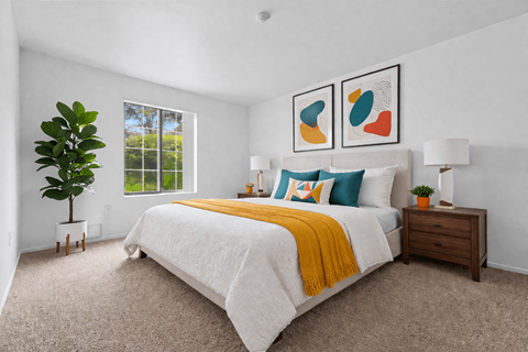 Bright bedroom with abstract wall art and yellow accent throw at Pilgrim Village - Canton, MI Apartments, Michigan, 48187