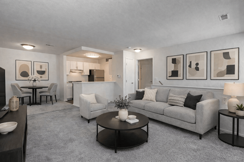 A living room with a grey couch, a coffee table, and a dining table with chairs.