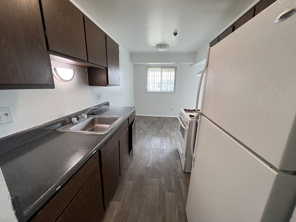 an empty kitchen with a sink and refrigerator