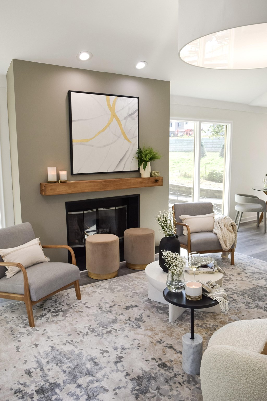 a living room with a fireplace and chairs and a rug