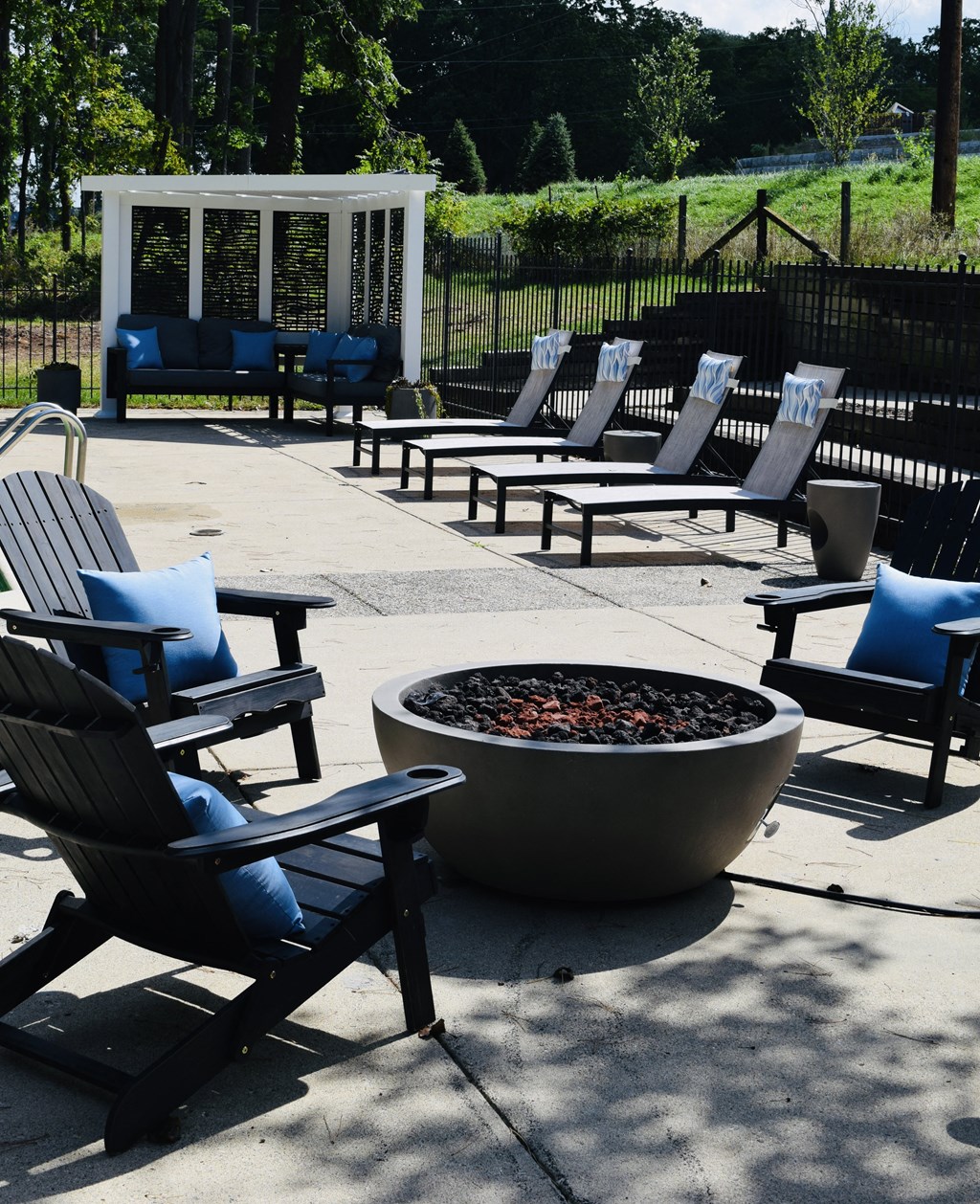 an outdoor seating area with chairs around a fire pit