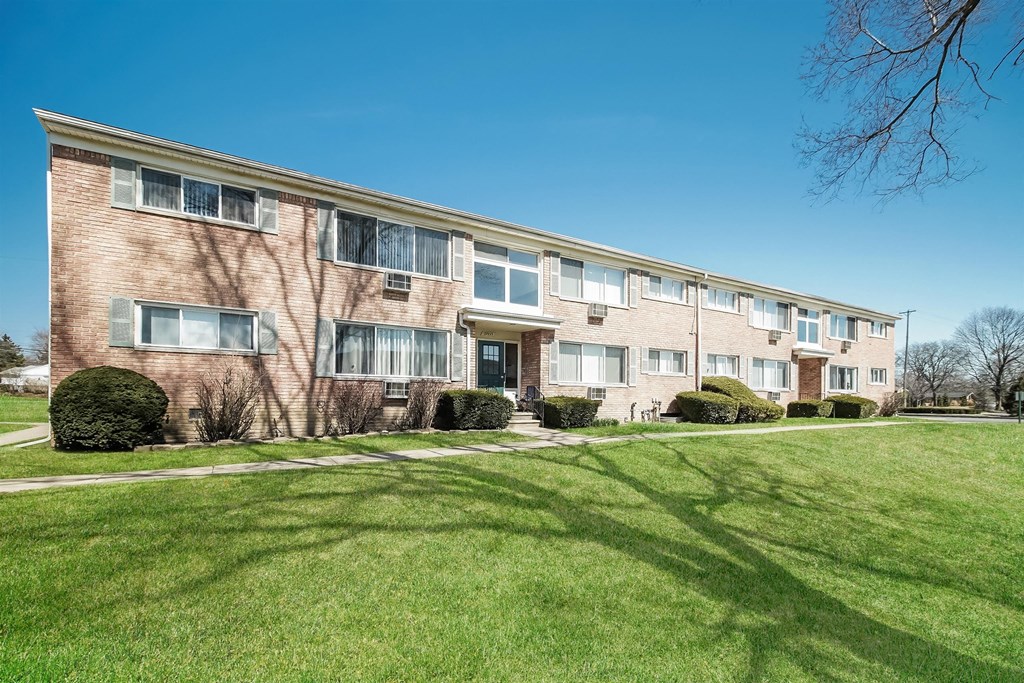 an office building with green grass and a blue sky