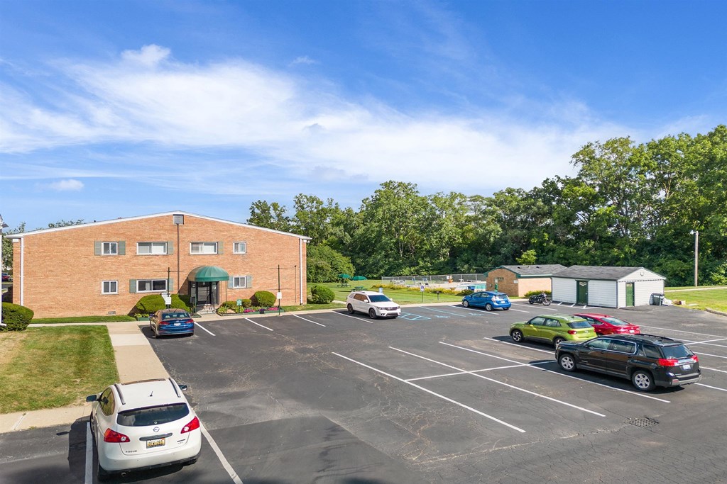 a parking lot with cars in front of a brick building