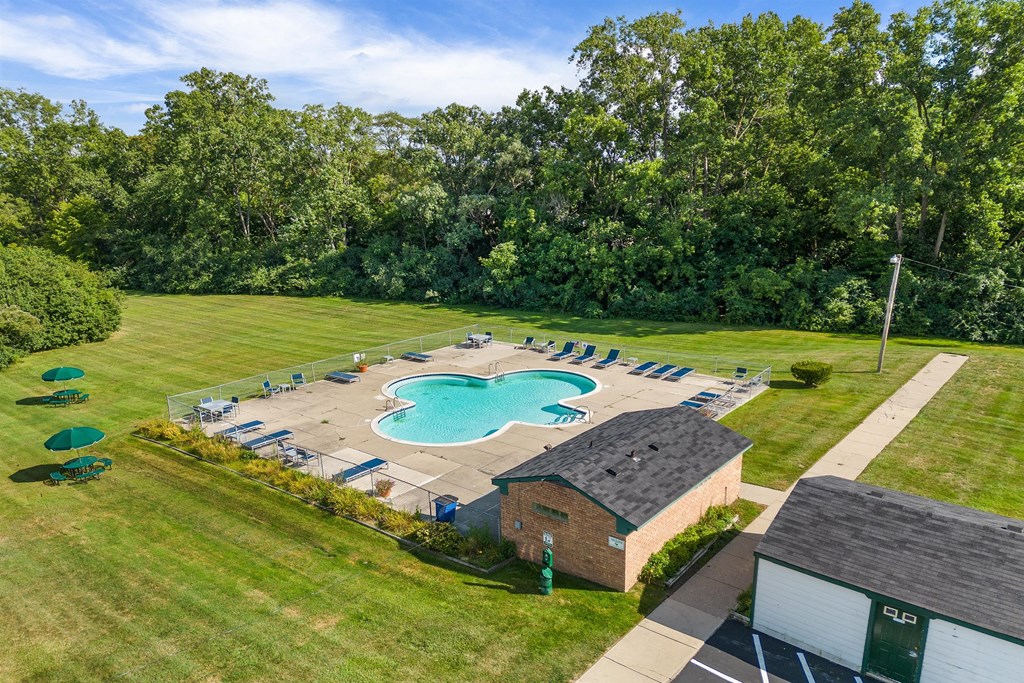 a aerial view of a swimming pool in the middle of a lawn and a building