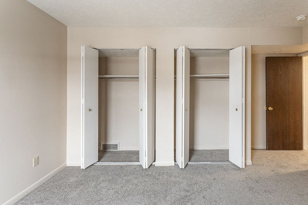 an empty room with three closet doors in it