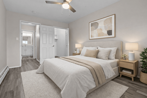 Spacious bedroom with ceiling fan and ensuite bathroom at Plymouth Heritage Apartments, Michigan