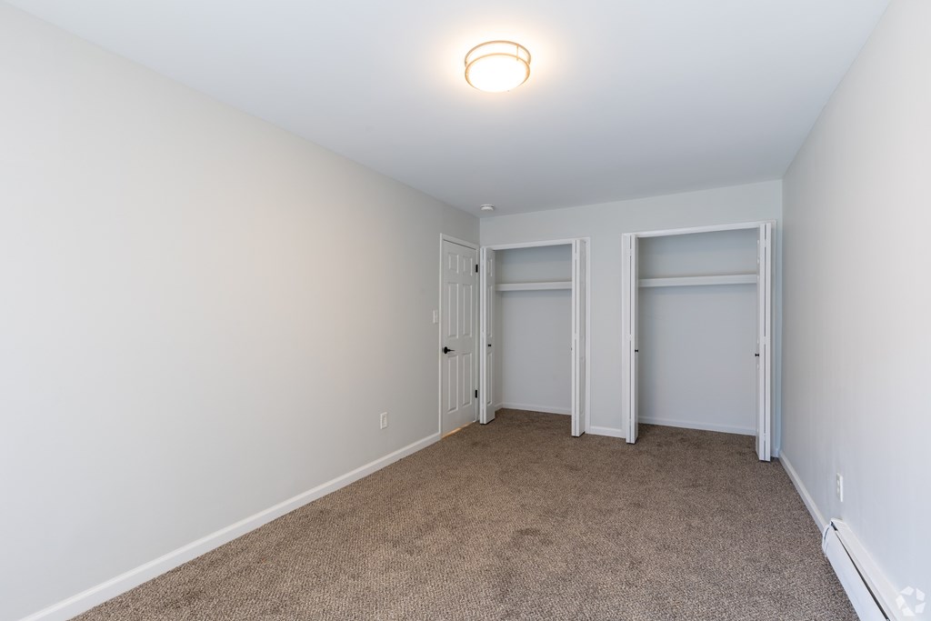 A room with white walls and carpeted floor.