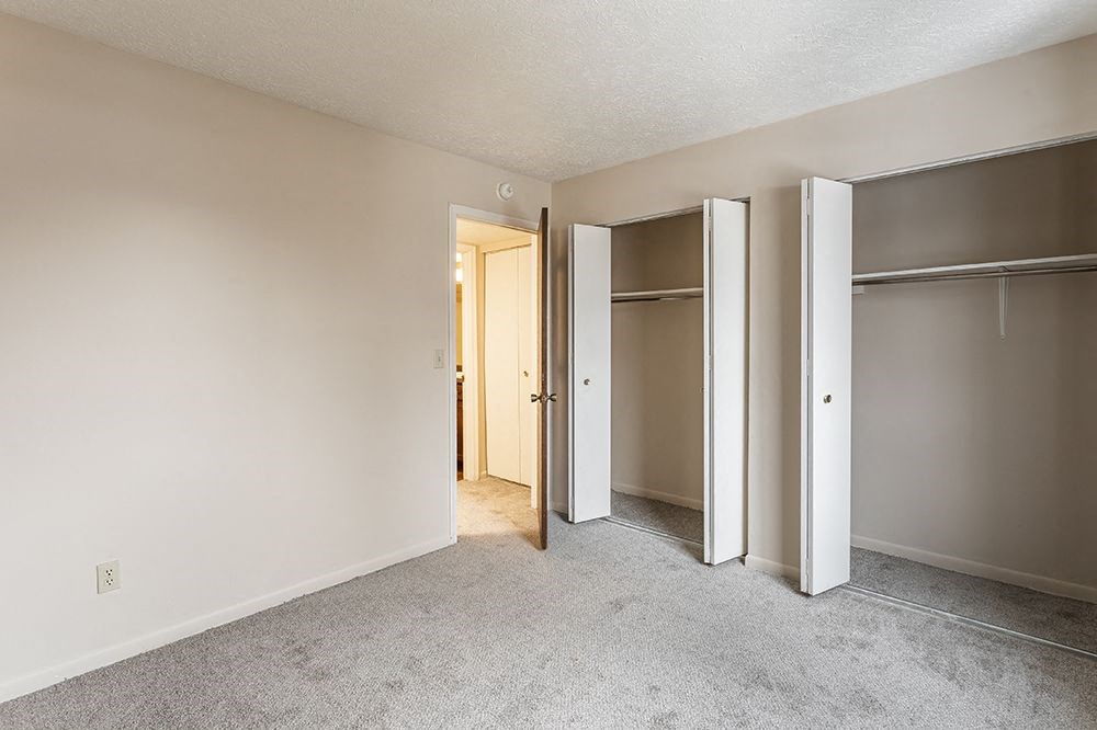 an empty bedroom with sliding closet doors