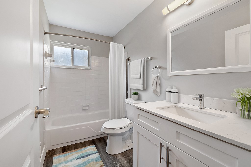 A white bathroom with a toilet, sink, and tub.
