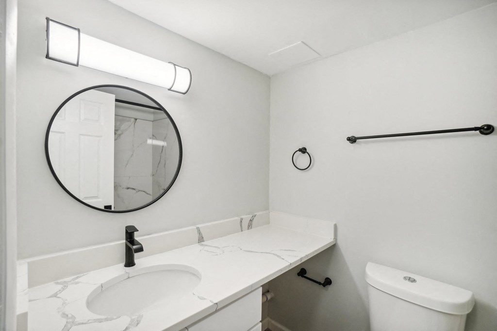 A bathroom with a white sink and toilet.