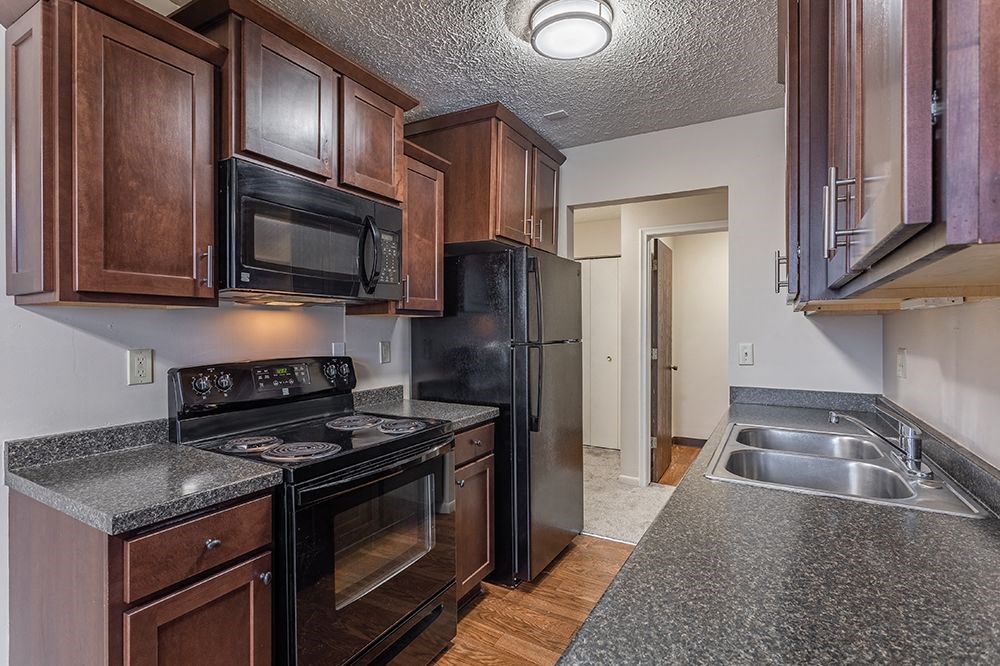 a kitchen with black appliances and granite counter tops