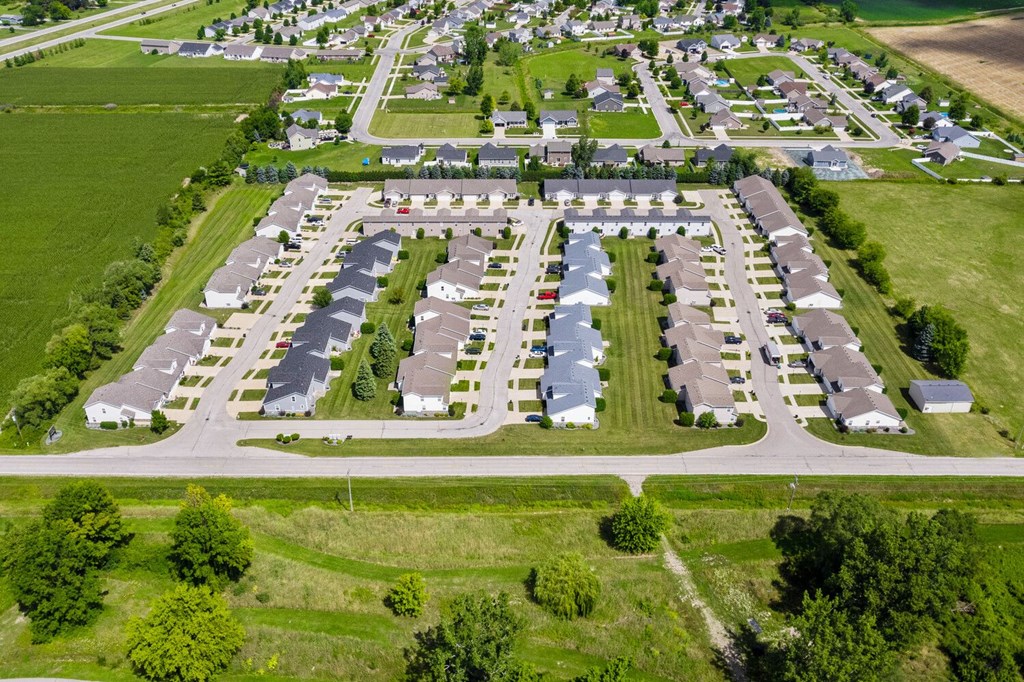 an aerial view of a parking lot with rows of cars