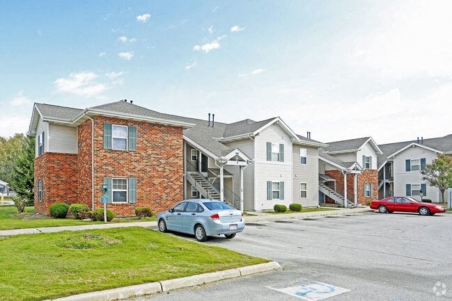 a row of houses with cars parked in front of them
