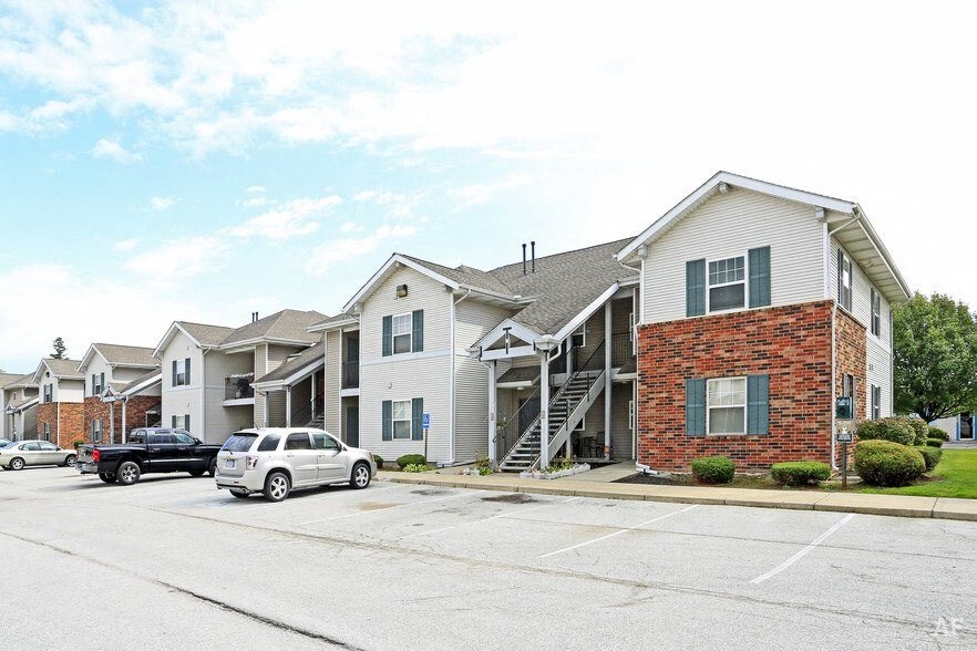 a row of houses with cars parked in front of them