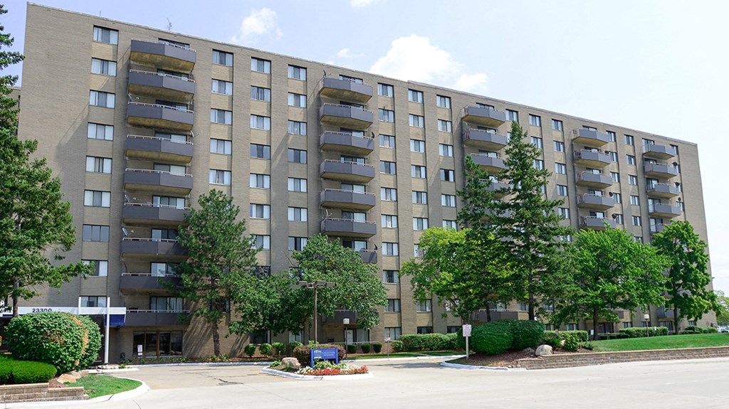 a large apartment building with trees in front of it