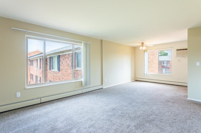 the living room of an empty house with large windows