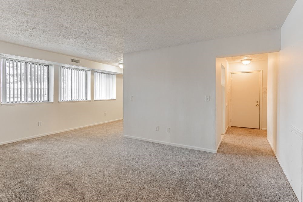 an empty living room with a door to a hallway
