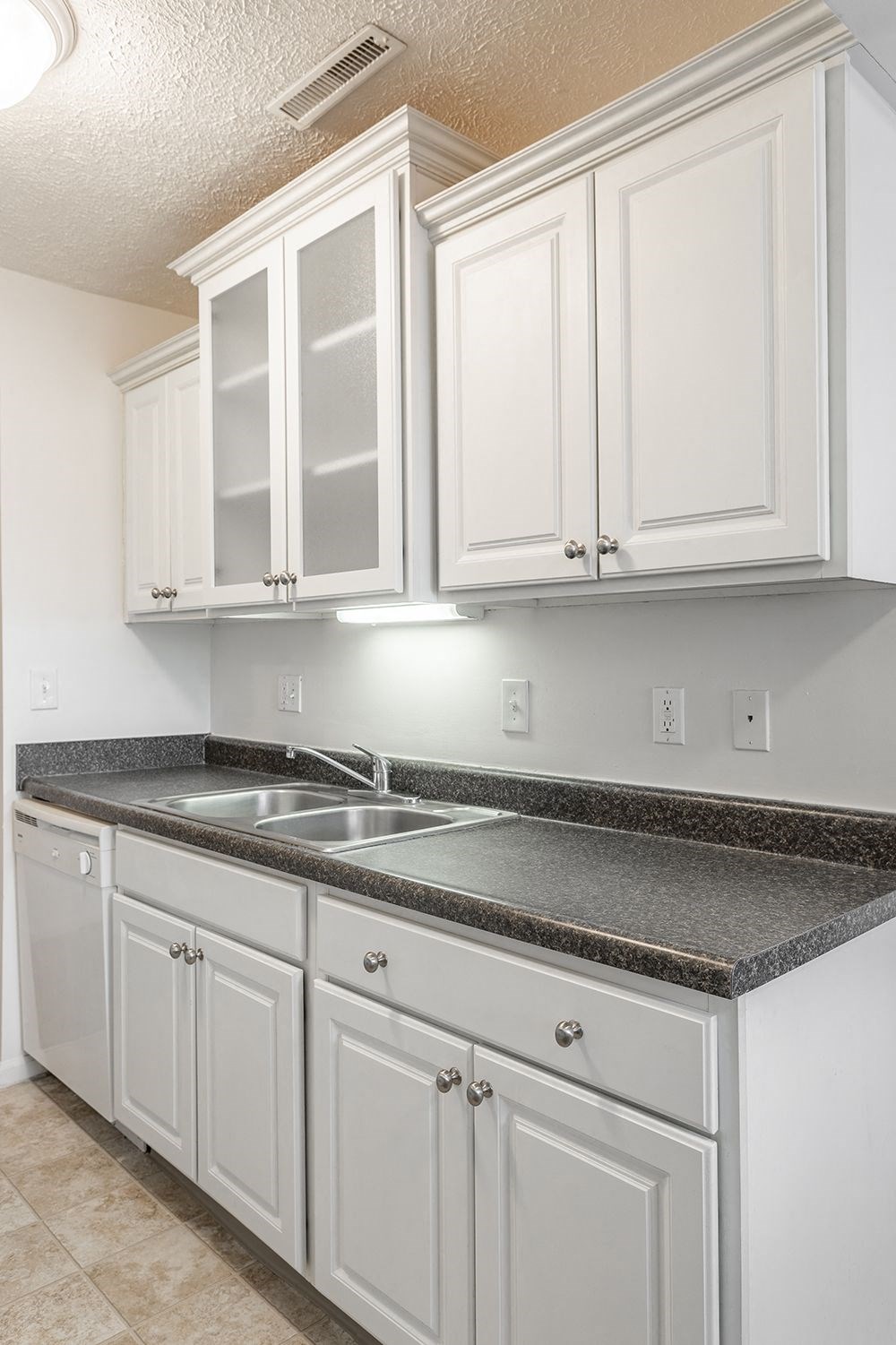 a kitchen with white cabinets and granite counter tops