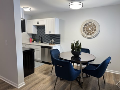 A kitchen with a dining table and chairs.