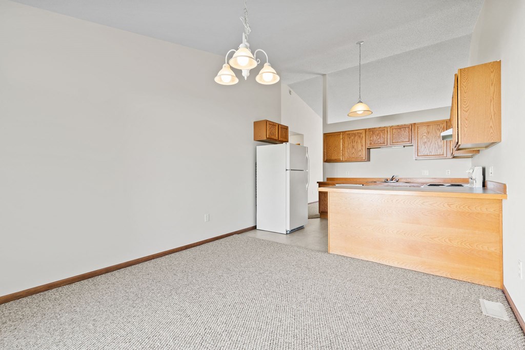 a kitchen with a white refrigerator and a wooden cabinet