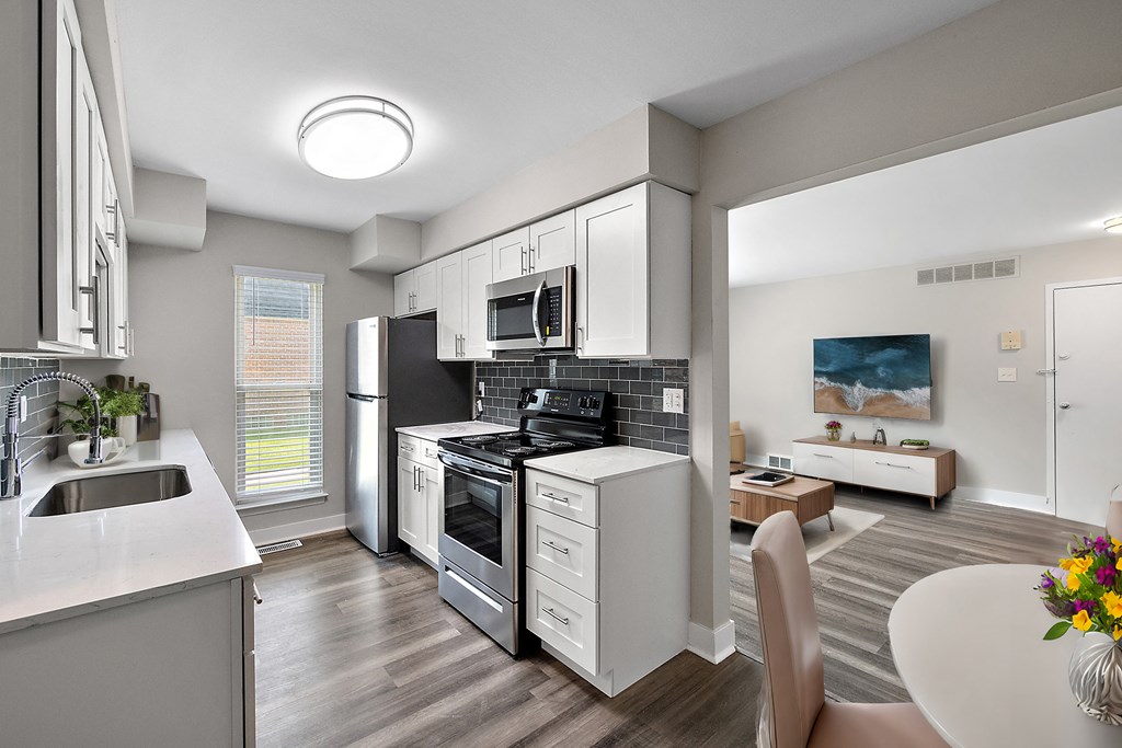 A modern kitchen with a refrigerator, oven, and sink.