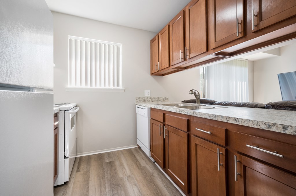 a kitchen with wooden cabinets and a sink and a window