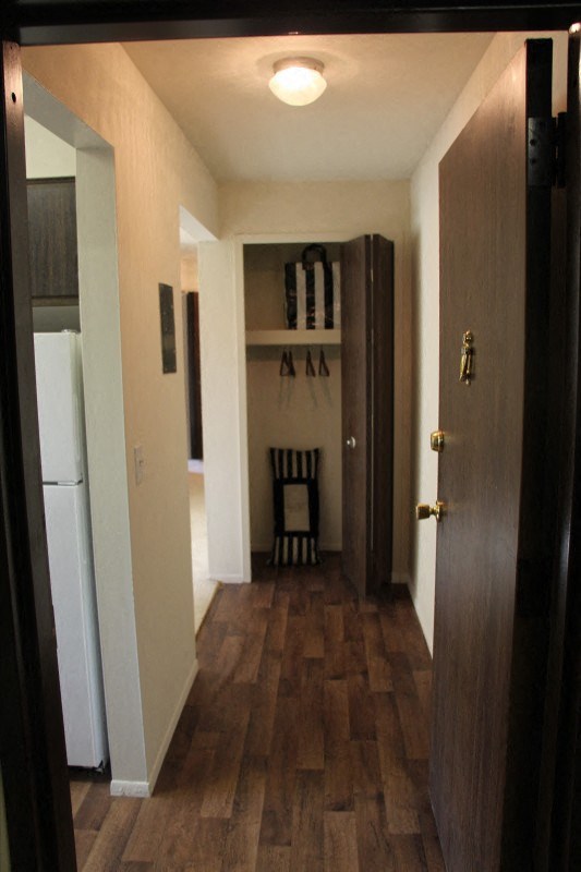 a room with a fridge and a chair in it