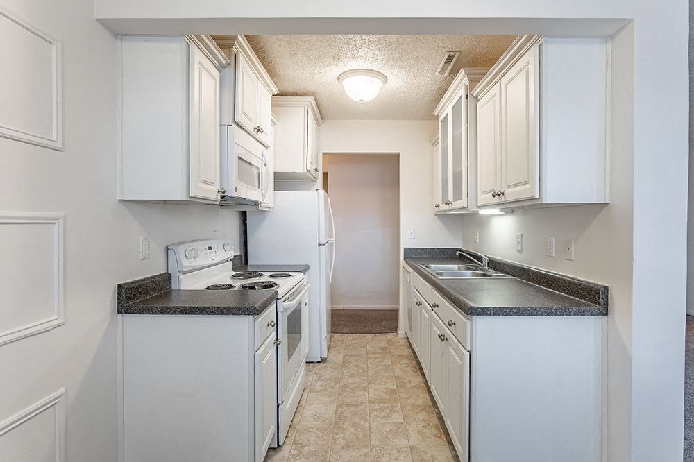 a kitchen with white appliances and white cabinets