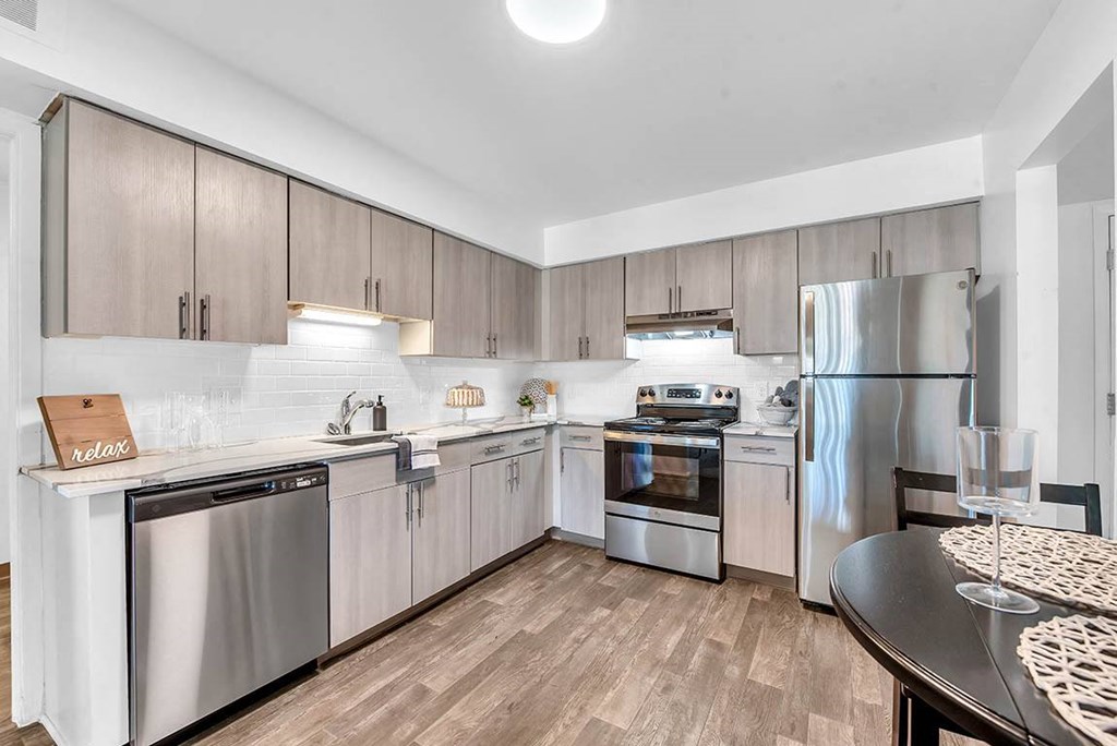 a kitchen with stainless steel appliances and wooden floors at Edge At Farmington Hills - Farmington Hills, MI, Michigan