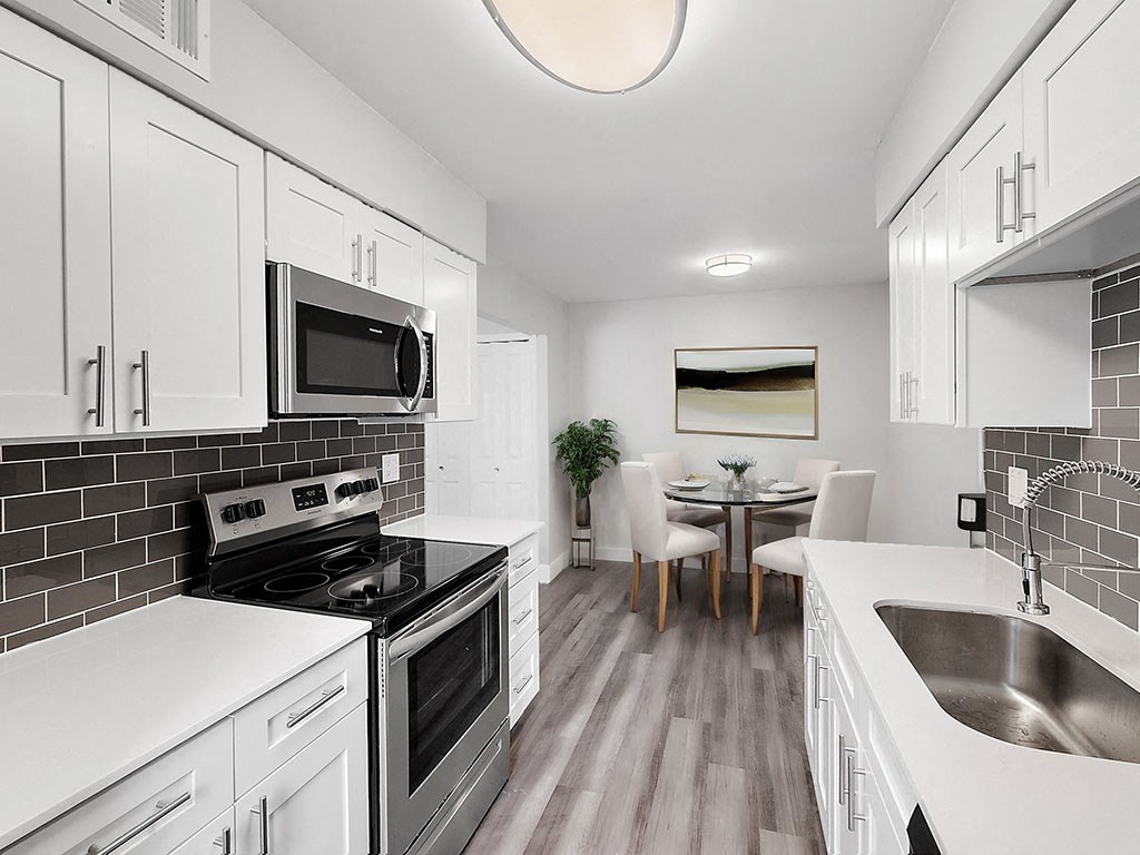 A modern kitchen with white cabinets and a black stove top.