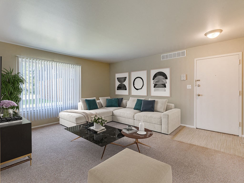 A living room with a white couch, a black coffee table, and a plant on the left side.