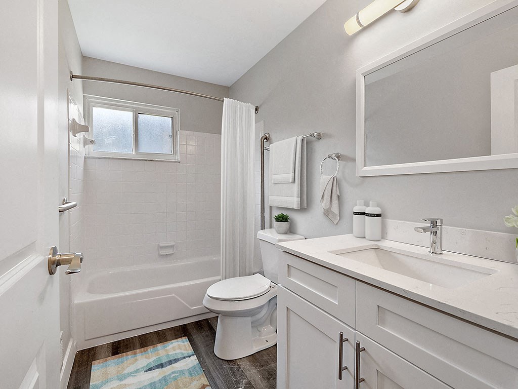 A white bathroom with a toilet, sink, and bathtub.