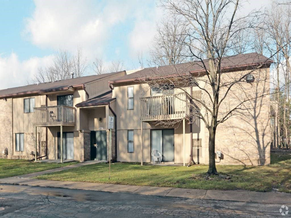 a building with two balconies and a tree in front of it