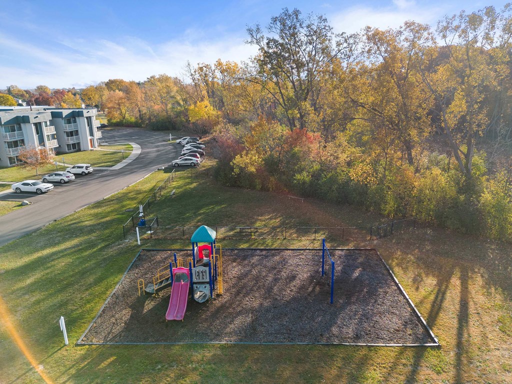 an aerial view of a playground at a park with trees