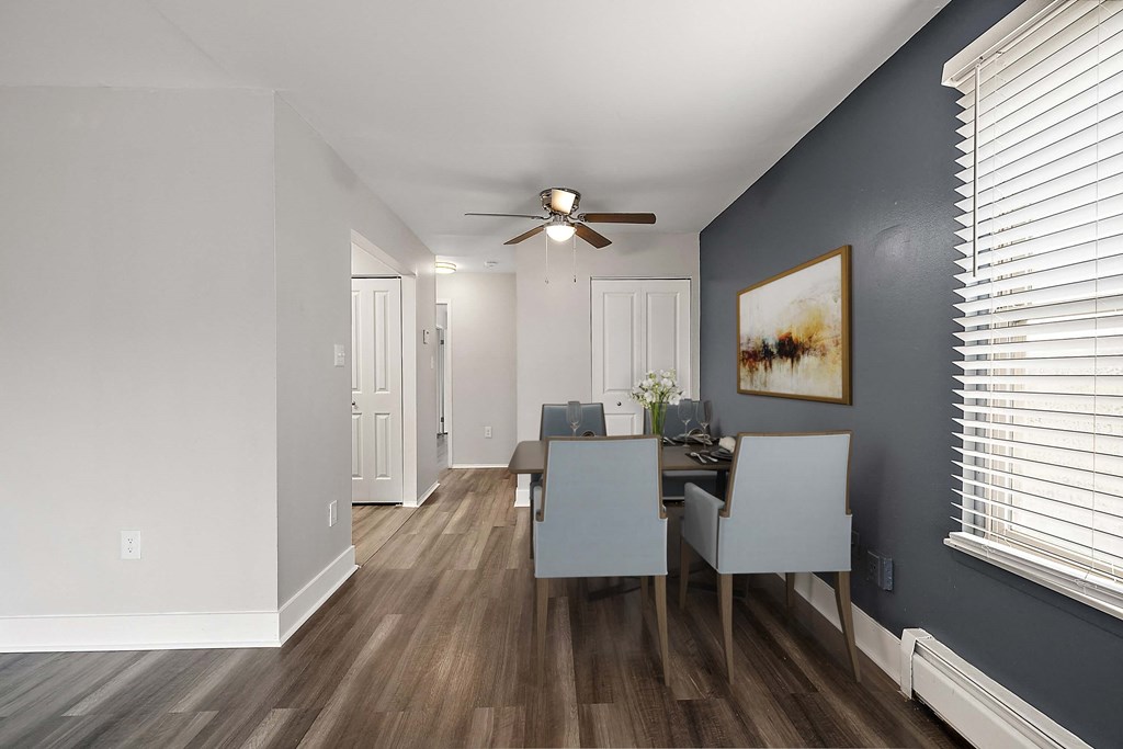 a dining room with a table and chairs and a ceiling fan