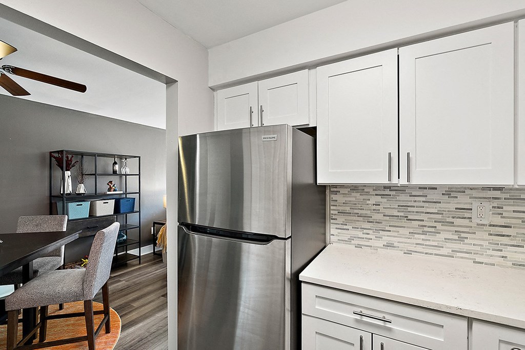 a kitchen with a stainless steel refrigerator and white cabinets