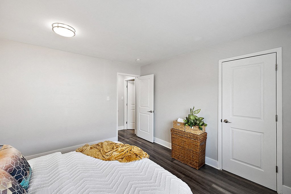 a bedroom with white walls and a bed with a yellow blanket