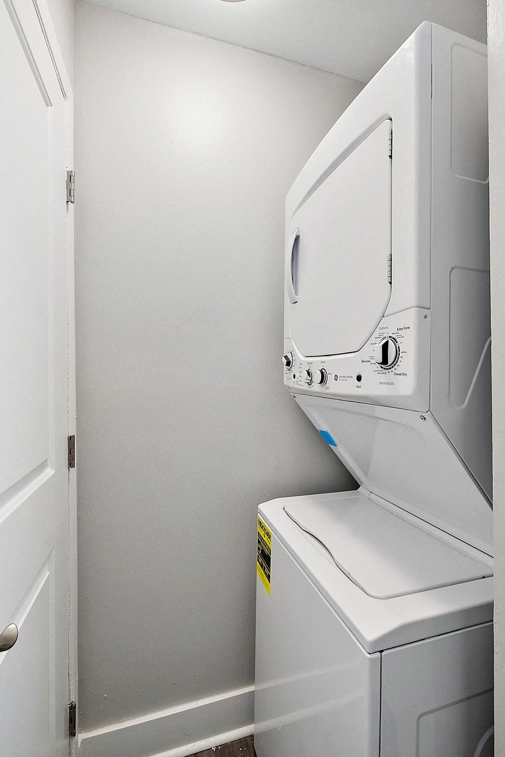 a washer and dryer in a white room with a door