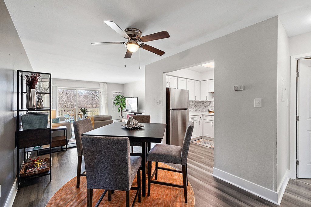 a living room with a dining room table and a ceiling fan