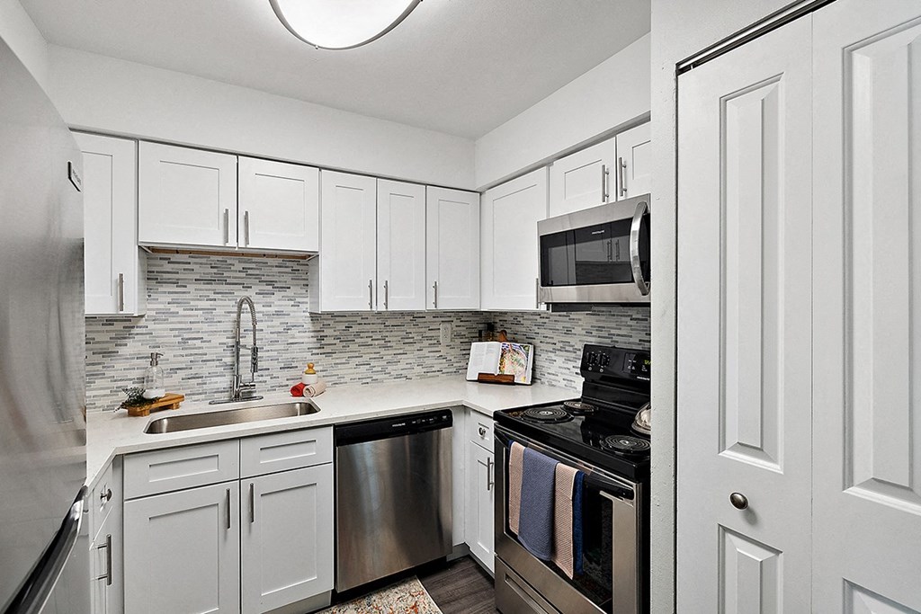 a kitchen with stainless steel appliances and white cabinets